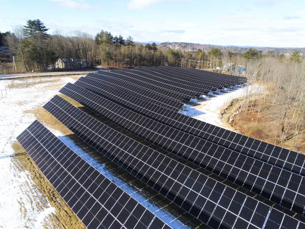 High-resolution solar panels installed on a large solar farm amid snowy terrain, representing renewable energy solutions.